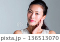 Serene Woman Gently Touching Her Cheek in Soft Studio Light 136513070