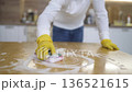 Man Using Gloves On Table. Focused On Cleaning Wooden Table With Thick Foam And Circular Motions 136521615