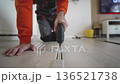 Detailed Scene Of Worker Carefully Repairing Laminate Flooring In Contemporary Living Space 136521738