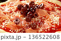 Super slow motion close-up of black olives falling onto fresh pizza with tomato sauce, mozzarella and ham. Dynamic food motion highlights texture, freshness and Italian pizza preparation concept. 136522608