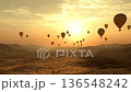 Barren land awakens as hot air balloons rise with the sun 136548242