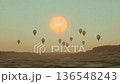 Barren land awakens as hot air balloons rise with the sun 136548243