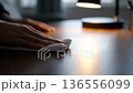 Close-up of person's hands wiping wooden table with white cloth, keeping it clean. 136556099