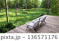 Animation of luxury wooden terrace with lounge chairs overlooking a lush green forest 3d render 136571176