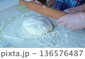 A mother and child roll out dough with a rolling pin, close-up of their hands. High quality 4k footage 136576487