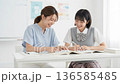 女子高生に勉強を教える若い女性教師 136585485