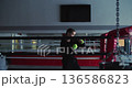 A teenage girl boxer moves with precision through shadow fighting exercises, sharpening her reflexes and strength in a focused gym environment. Slow motion 4k footage. 136586823