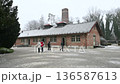 DDachau, germany, december 27, 2025. Visitors walking in front of the crematorium building at the concentration camp memorial site on a cold, snowy winter day. 136587613