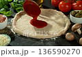 Super Slow Motion of Pouring Tomato Sauce on Pizza Dough . Closeup of Pizza Preparation 136590270
