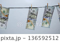 Money bills hanging on a line, showcasing financial themes, with a gradual zoom in emphasizing the details of the currency 136592512