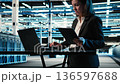 Data center specialist crosschecking settings between laptop and tablet, monitoring industrial systems. Server room computer scientist using devices to oversee network gear performance, camera A 136597688