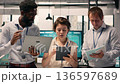 Portrait multiethnic team, working together in office, reviewing business reports, visual data. Corporate collaboration, forecasting and planning, achieving organizational goals, business intel. 136597689