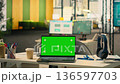 Green screen laptop at workstation in empty bright open office, modern corporation space with furniture and office supplies. Comfortable work environment with natural light. 136597703