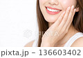 手で頬を触りスキンケアする笑顔の若い女性。美容イメージ 136603402