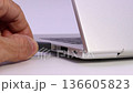 hand inserting usb flash drive into laptop port for data storage and file transfer 136605823