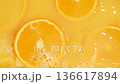 Slow motion of fresh slices of oranges splashing in orange juice. 136617894