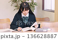 Female high school student/exam taker studying seriously at a desk Female high school student/exam taker studying seriously at a desk 136628887