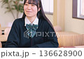 Smiling female high school student studying positively in a bright classroom Smiling female high school student studying positively in a bright classroom 136628900