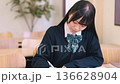 Female high school student/exam taker studying seriously at a desk Female high school student/exam taker studying seriously at a desk 136628904