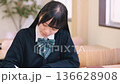 Female high school student/exam taker studying seriously at a desk Female high school student/exam taker studying seriously at a desk 136628908