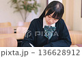 Female high school student/exam taker studying seriously at a desk Female high school student/exam taker studying seriously at a desk 136628912