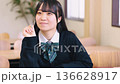 Smiling female high school student studying positively in a bright classroom Smiling female high school student studying positively in a bright classroom 136628917