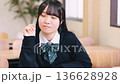 Smiling female high school student studying positively in a bright classroom Smiling female high school student studying positively in a bright classroom 136628928