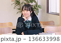 Smiling female high school student studying positively in a bright classroom Smiling female high school student studying positively in a bright classroom 136633998