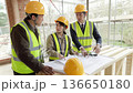 一名女工地主管正在建築工地上交代工務員的工作。 136650180