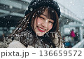 雪の降る都会で笑顔を見せる日本人の若い女性 136659572