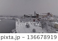 Drone view of snowy Wawel Castle in Krakow from the Vistula River.  136678919