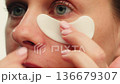 Young woman with eye pathes on her face close-up. Facial Skincare. Hydrogel cosmetic eye patches in 136679307