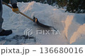 Snow Being Pushed Aside With Shovel on Icy Pavement 136680016