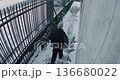 External Security Camera Records Man in Winter Jacket and Cap Walking Down Snow Cleared Sidewalk 136680022