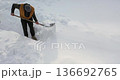 Focused and persistent, a man carves a way through heavy snowdrifts, demonstrating methodical effort and endurance in the face of a snowy challenge. 30 FPS 4k footage. 136692765