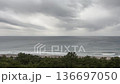 Coastal scenery of the dark sea with rough waves crashing against the shore and pine forest swaying in the wind under a cloudy sky in Kamogawa, Chiba Prefecture 136697050