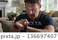 Concerned man checking heart rate on smartwatch 136697407