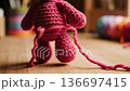 Pink crocheted amigurumi teddy bear unraveling 136697415