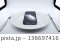 Smartphone addiction concept featuring phone on a plate with cutlery 136697416