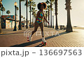 Happy african american woman roller skating on the beach promenade 136697563