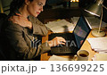 A woman who works overtime until late at night and continues working on a computer while enduring severe shoulder stiffness 136699225