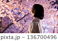 A woman looking at cherry blossoms at night 136700496
