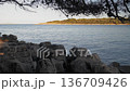 Rocky Seashore with Calm Blue Sea and Island View 136709426