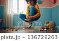child tying sneakers in playroom floating midair, focused expression, scattered wooden blocks and teddy on hardwood floor, warm window light, pastel walls, cozy aesthetic, playful 136729263