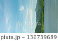 Timelapse vertical. A reservoir with lush green mountains and a blue sky. 136739689