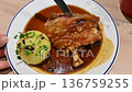 Munich, germany, december 27, 2025. Traditional bavarian roasted pork knuckle, schweinshaxe, with crispy skin served with a potato dumpling and savory gravy in a restaurant 136759255