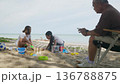 Happy family beach vacation, child and woman actively play with vibrant sand toys on sunny shore, man relaxing on chair watches idyllic summer travel trip. 136788875