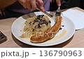 Munich, germany, december 27, 2025. Delicious traditional german meal of bratwurst and sauerkraut being eaten with a knife and fork. A classic european cuisine dish for dinner 136790963