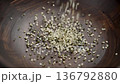 Organic hulled hemp seeds falling into a wooden dish. Natural nutritional supplement. Healthy culinary ingredients. Slow motion. Rotation 136792880
