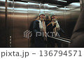 Woman enters elevator and presses button wearing a winter outfit in a building 136794571